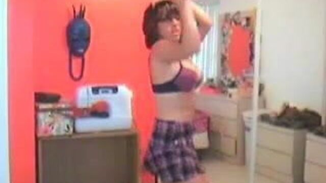 Привлекательная молодая женщина раздевается перед ее вебкамерой