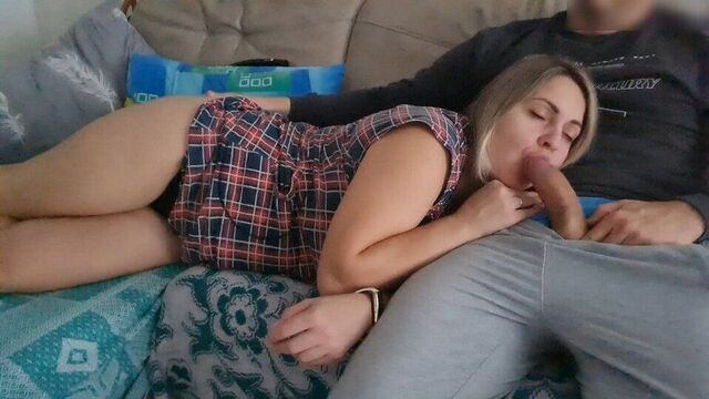 Сводная сестра лежит на коленях ее сводного брата, и он неожиданно начинает мастурбировать его хуй возле ее рта