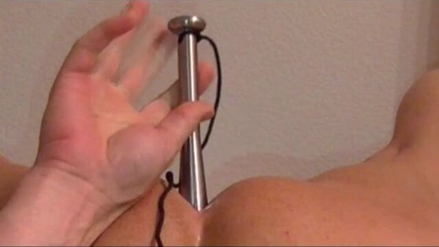 Heavy steel dildo buried in her butt