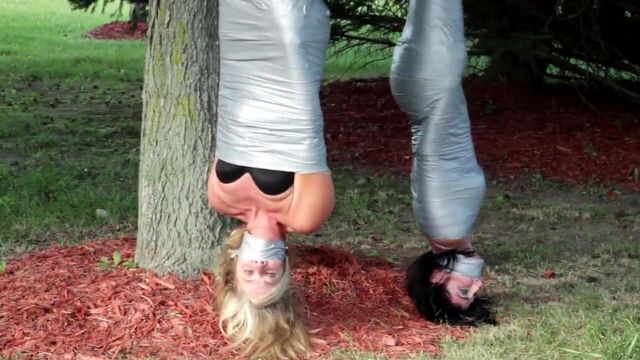 Две девушки мумии клейкой лентой на улице