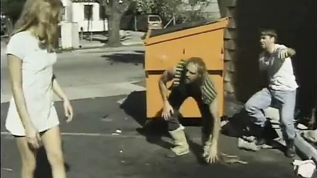 Молодая девушка в переулке на переулке бездомными